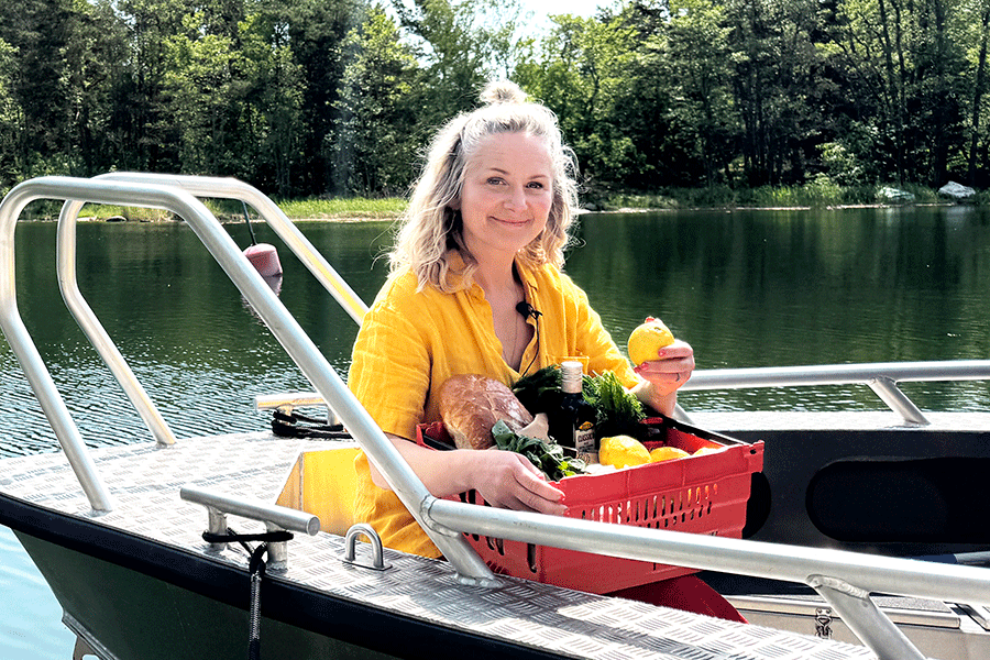 Lisa Lemke sitter i båt med färskvaror från Menigo.